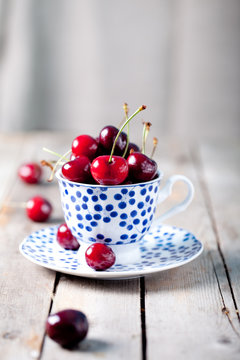 Fresh cherry in a blue ceramic cup
