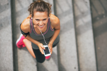 Portrait of smiling fitness young woman with cell phone 