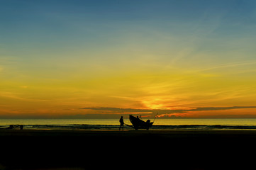 Fototapeta na wymiar fisherman at beach during sunrise