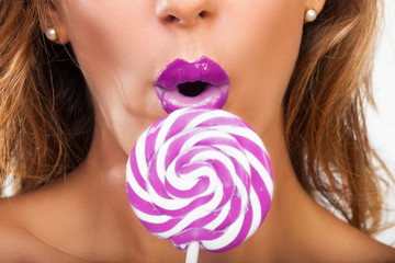 Sexy girl with a purple lollypop