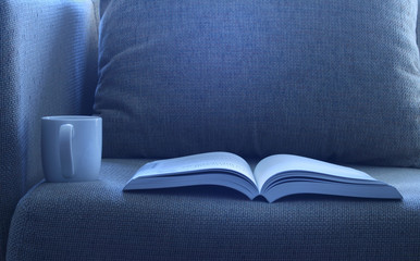 Open book with a cup of cofee on bed