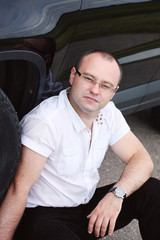 Happy young man driver near a car.