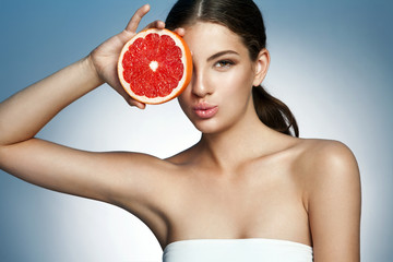 Lovely girl with pomelo slice, natural organic raw food