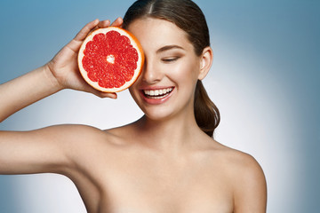 Smiling girl with grapefruit