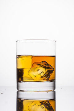 Whisky splashing in glass on a white background