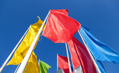 Colorful flags on blue sky background