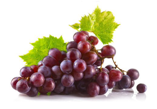 Bunch of ripe red grapes with leaves isolated on white