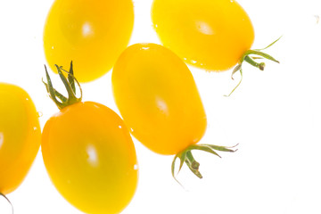 Yellow cherry tomatoes on white background.