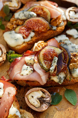 Crostini with prosciutto ham, frigs, blue cheese and walnuts