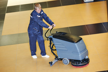 Fototapeta na wymiar worker cleaning floor with machine
