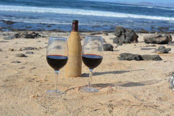 Two Wine Glasses And Bottle On The Beach With