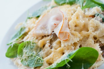 Farfalle pasta with ham, mushrooms, fresh spinach and cheese