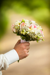 male hands holding a bouquet of flowers