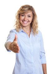 Frau mit blonden Locken reicht die Hand