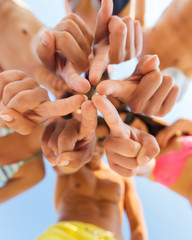 close up of friends in circle on summer beach