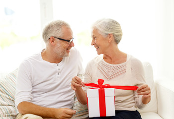 happy senior couple with gift box at home