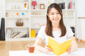 部屋で本を読む女性