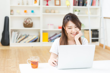 部屋でパソコンを使う女性