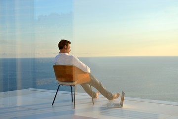 relaxed young man at home on balcony