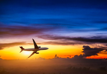 Fototapeta na wymiar Airplane in the sky at sunrise
