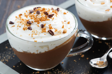 chocolate dessert with cream and amaretti in cups, close-up