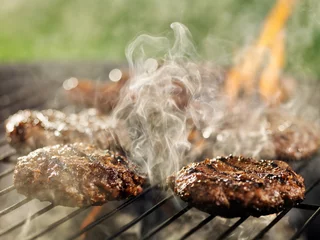 Crédence de cuisine en verre imprimé Grill / Barbecue hamburgers and hotdogs with smoke and flames on grill