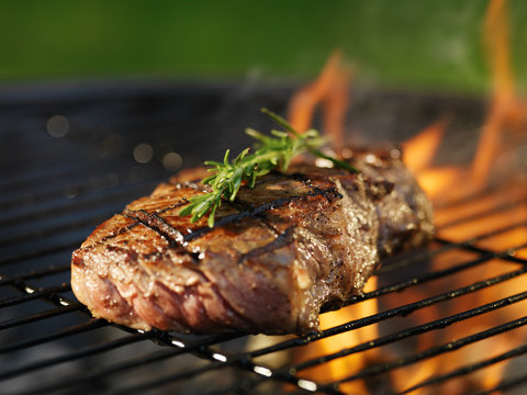 Steak With Flames On Grill With Rosemary