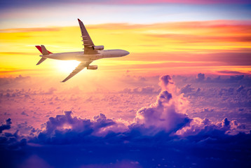 Fototapeta na wymiar Airplane in the sky at sunrise