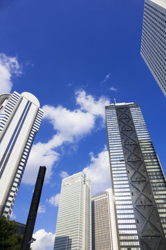 ［東京都市風景］青空に流れる白い雲と新宿高層ビル街を見上げる