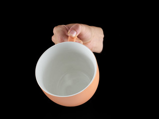 Orange - apricot color cup - mug on black background.