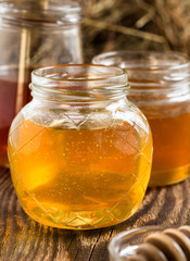 Honey in a glass jars on a wooden rustic background