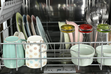 Open dishwasher with clean utensils in it