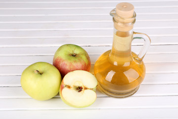 Apple cider vinegar in glass bottle and ripe fresh apples,