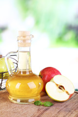 Apple cider vinegar in glass bottle and ripe fresh apples,