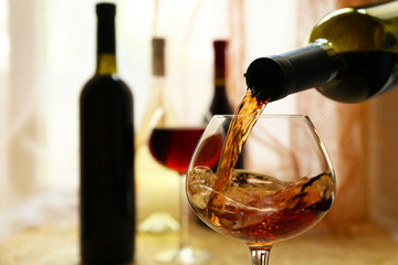 Red wine pouring into wine glass, close-up