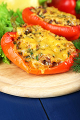 Stuffed red peppers with greens and vegetables on table close