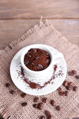 Mug of coffee beans and ground coffee