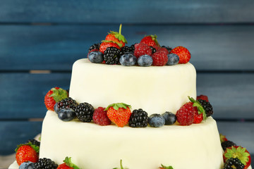 Beautiful wedding cake with berries on  dark wooden background