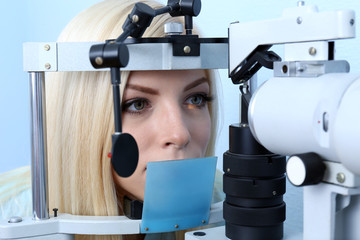 Optometry concept - pretty young woman having her eyes examined