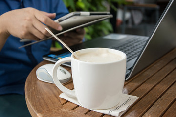 man with a cup of coffee working on his laptop