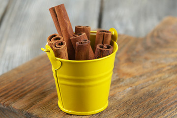 Cinnamon bark in pail on wooden table
