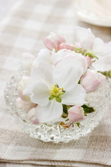 Table decoration of blooming apple tree flowers in crystal bowl