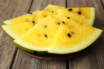 Slices of yellow watermelon on wooden background
