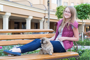 girl with a dog on a bench