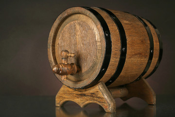 Barrel on wooden table on dark background
