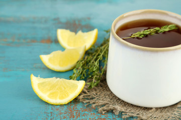 Cup of tasty herbal tea with thyme and lemon