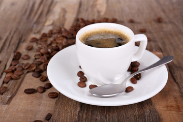 Cup of coffee and coffee beans on wooden background