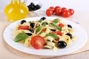 Fototapeta na wymiar Spaghetti with tomatoes, olives, olive oil and basil leaves