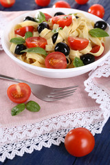 Spaghetti with tomatoes, olives and basil leaves