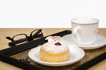 Image of donut in white dish on white and brown sack background